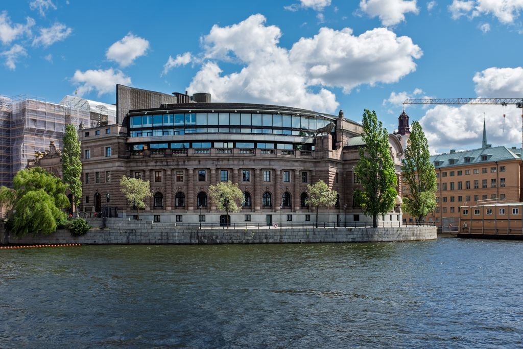 Riksdag building in Stockholm with clear skies and water view. Iconic Scandinavian architecture.